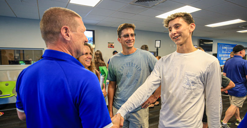 athlete and parents talking with a college coach
